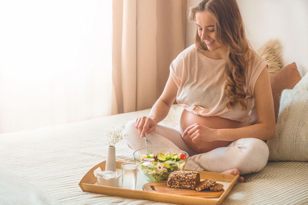 Pregnant woman enjoys organic salad