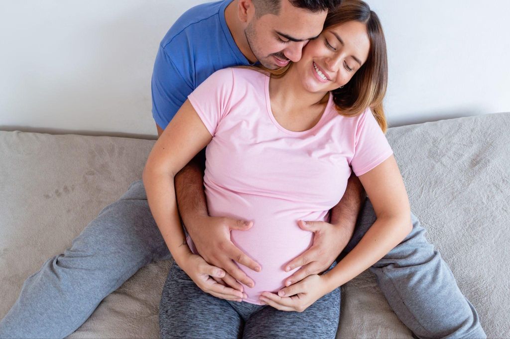 A pregnant couple enjoying a moment of closeness, showing love and support.