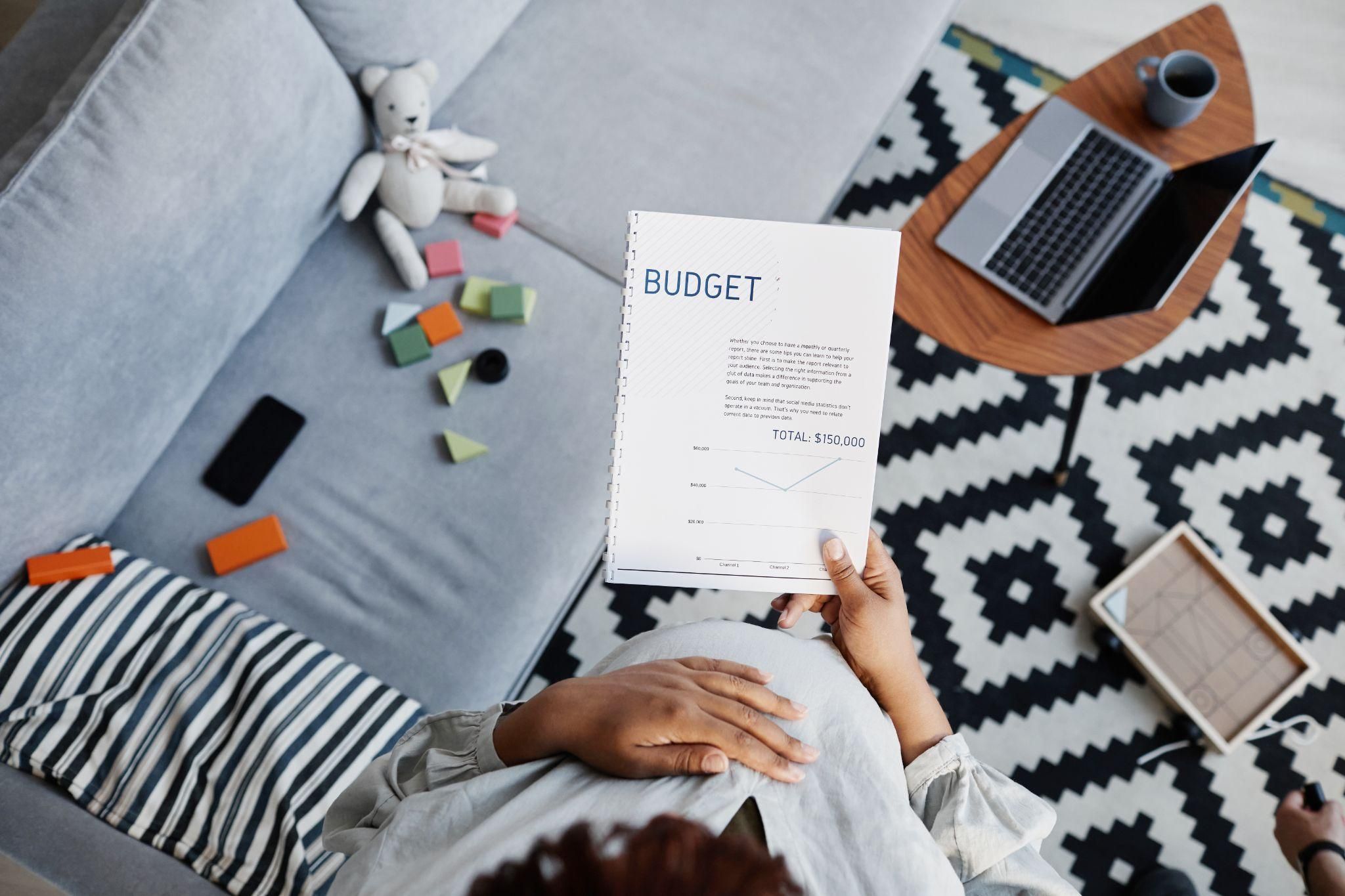 Expecting parents discussing money-saving tips while budgeting.