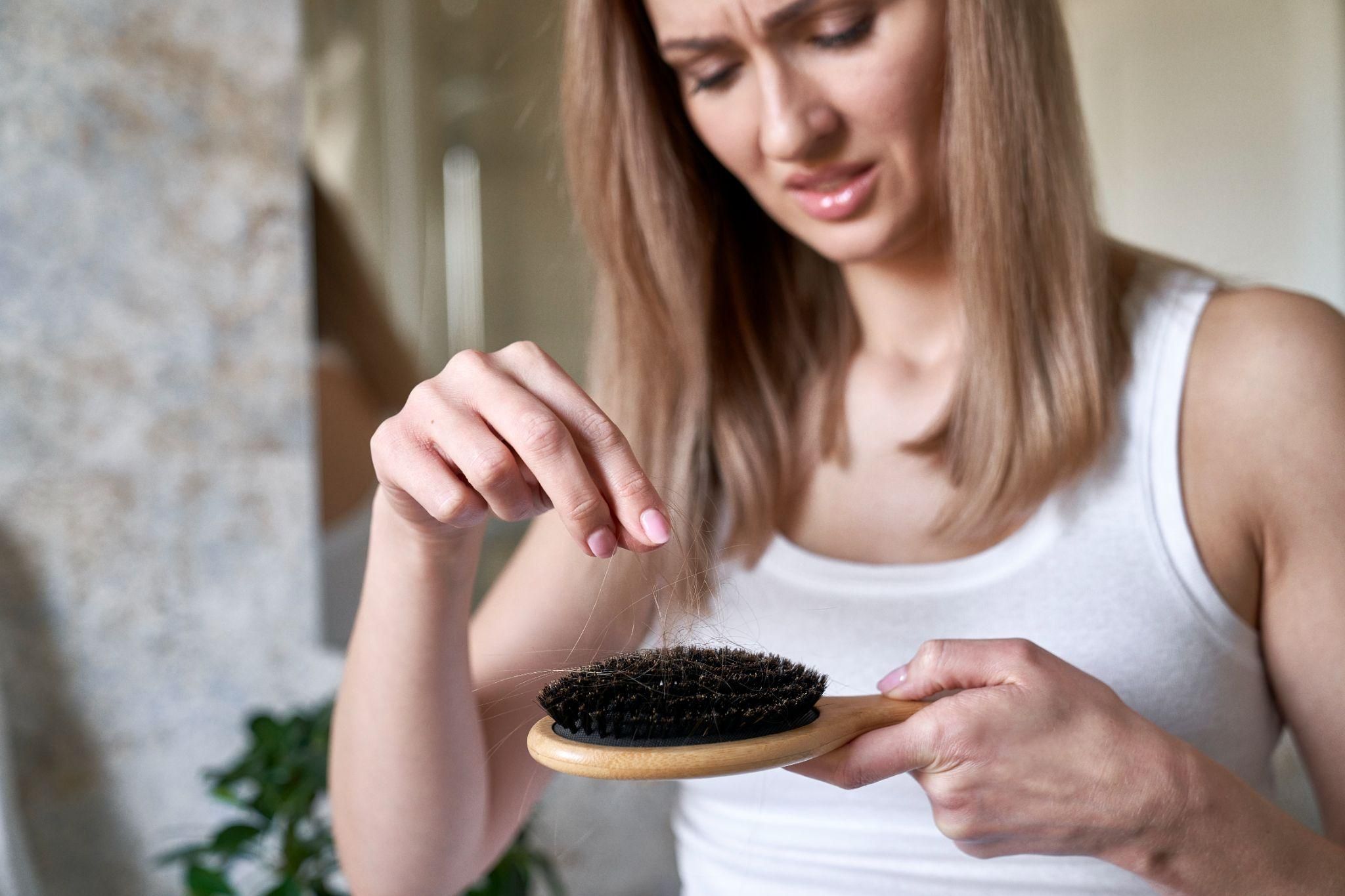 A mum observing excessive hair in her brush after childbirth.