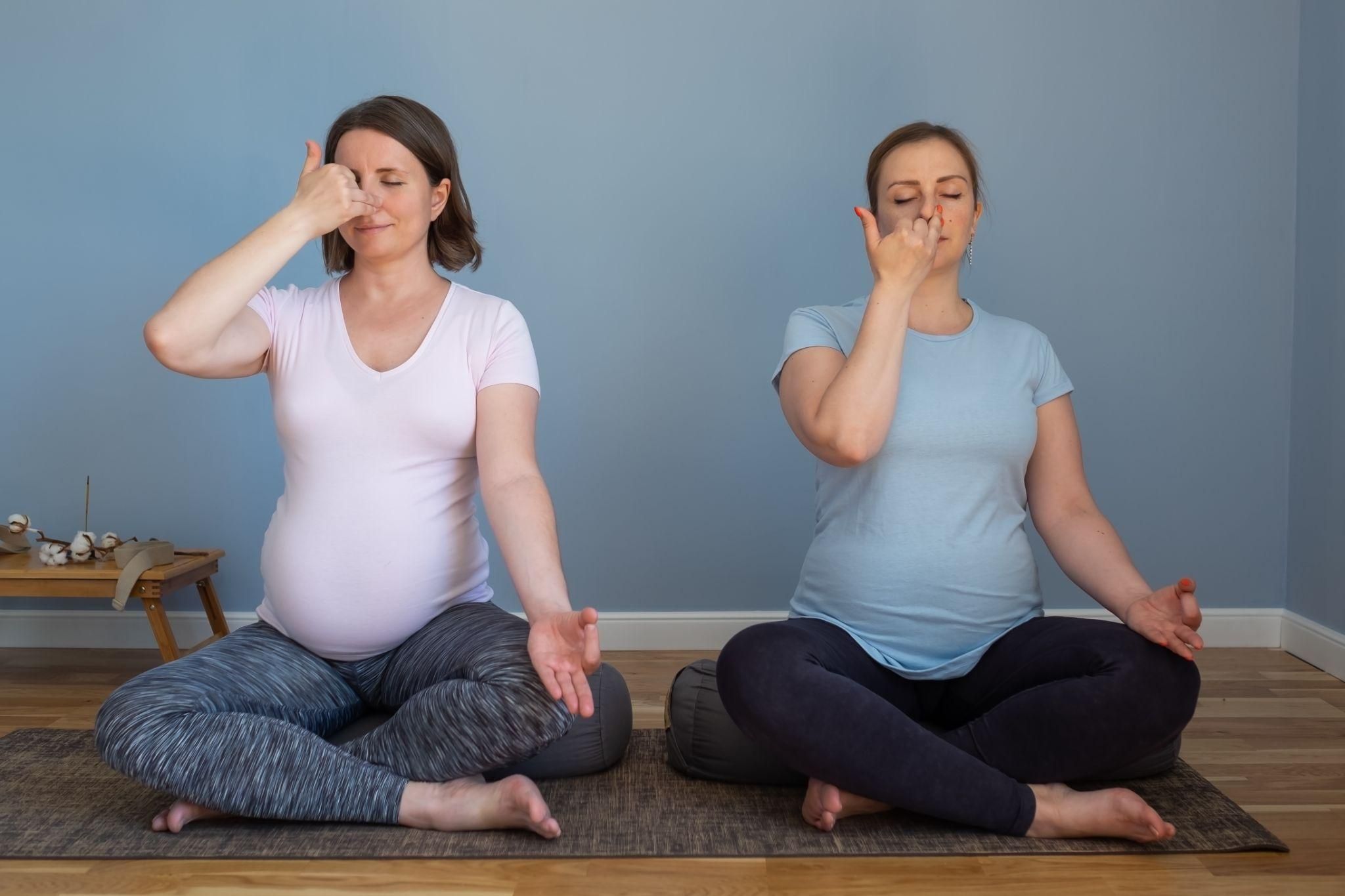 Serene pregnant women focusing on antenatal breathing exercises.