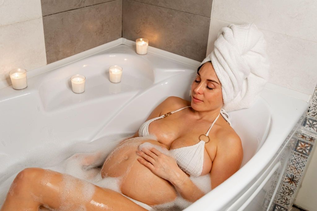 Midwife supporting a pregnant woman during a home birth in a cosy room.