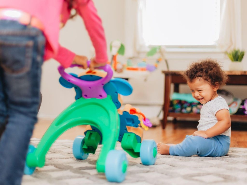 Baby walkers displayed in a playroom, highlighting interactive trays and sturdy designs.