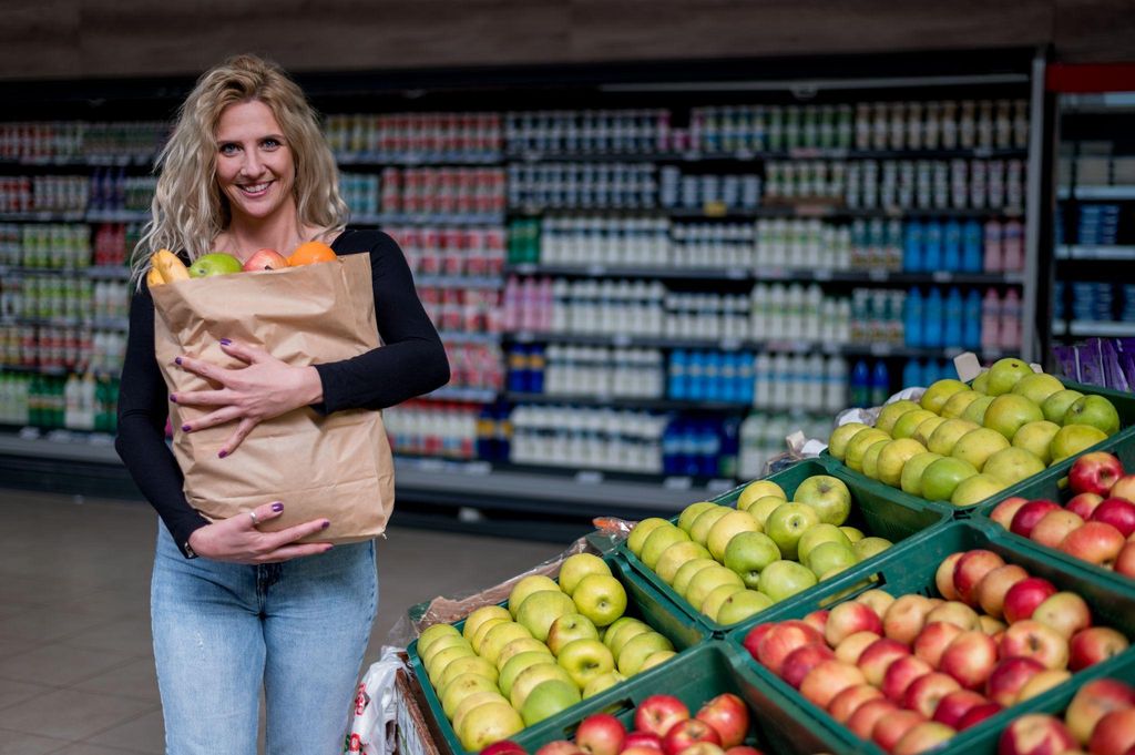 Pregnant woman choosing fresh fruits and vegetables at a London health food store.