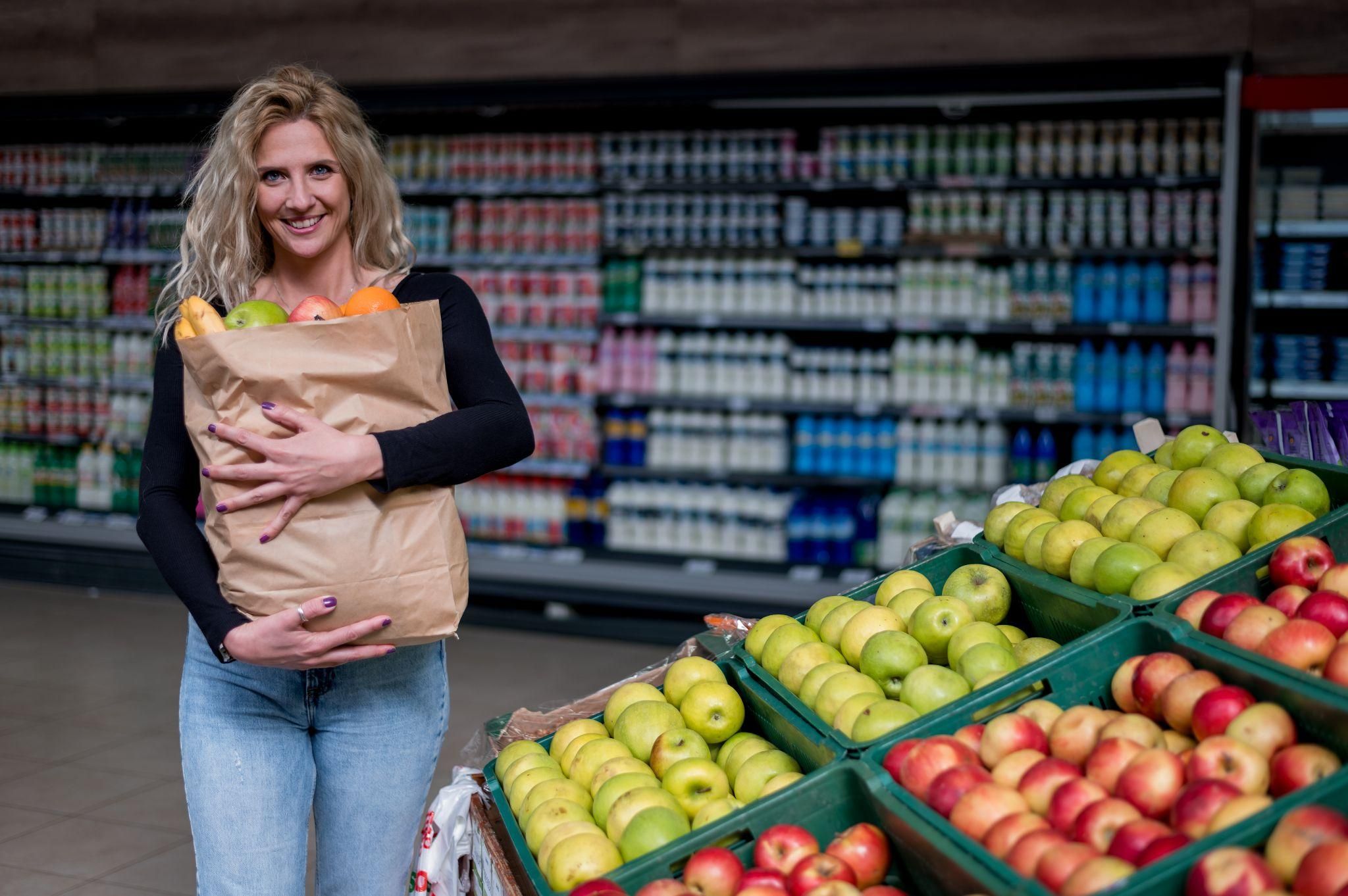 Pregnant woman choosing fresh fruits and vegetables at a London health food store.