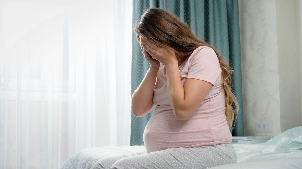 Pregnant woman in a calm, organised nursery preparing for her baby’s arrival.