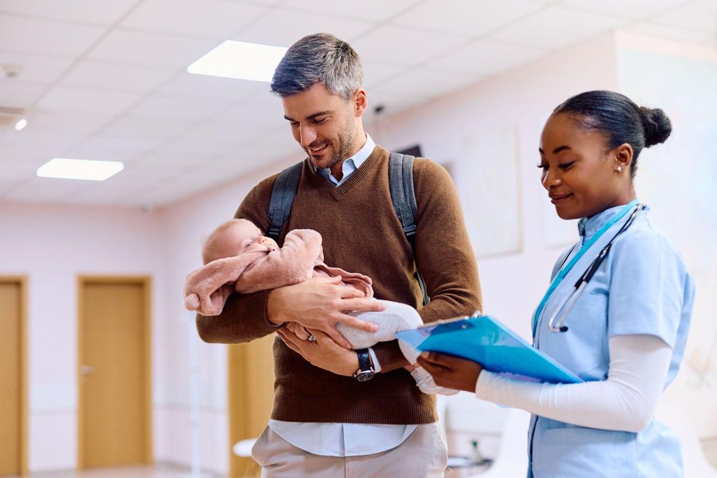 A dad engaging with his baby’s Red Book to track health milestones and vaccinations.