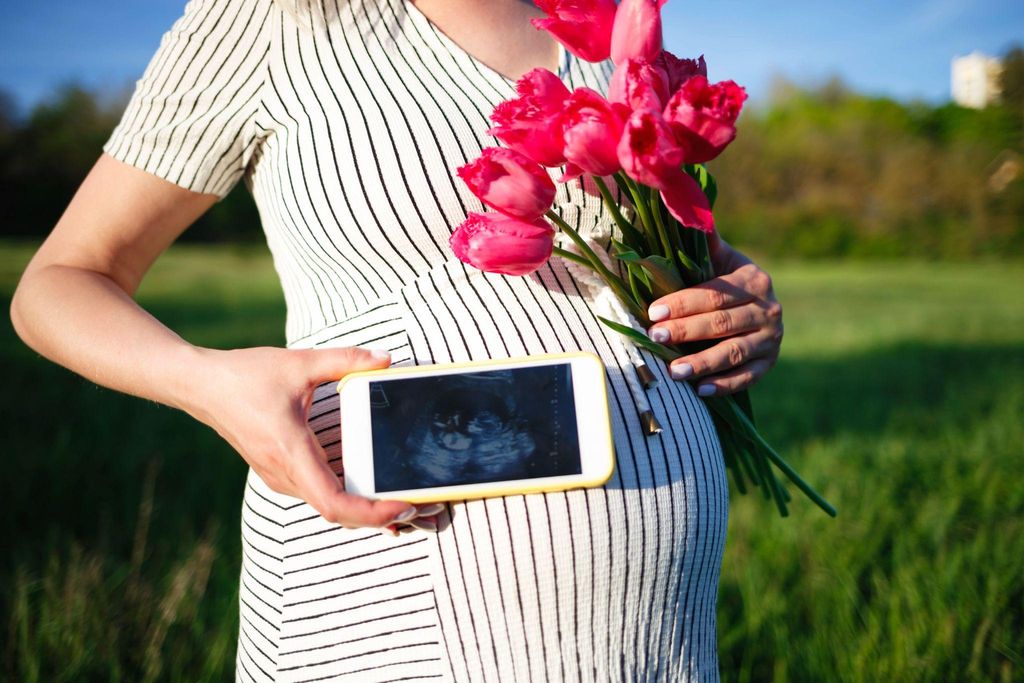 Pregnancy influencer shows ultrasound photo.