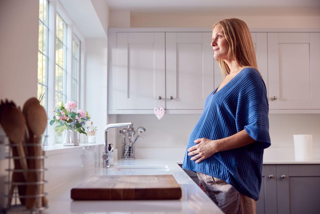 A mother standing confidently with her baby after C-section recovery.