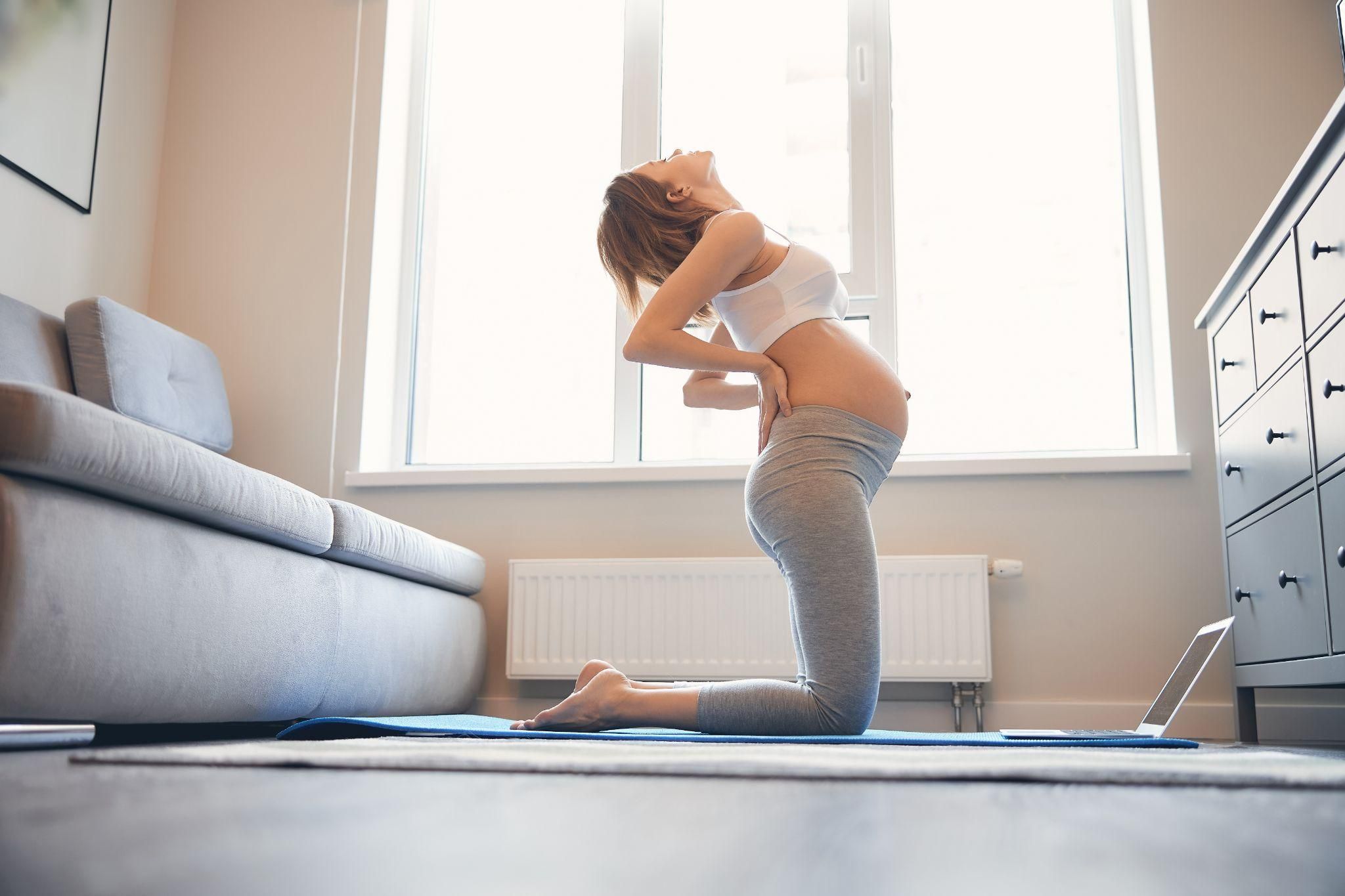 A woman in labour with her partner applying a warm compress to her back.