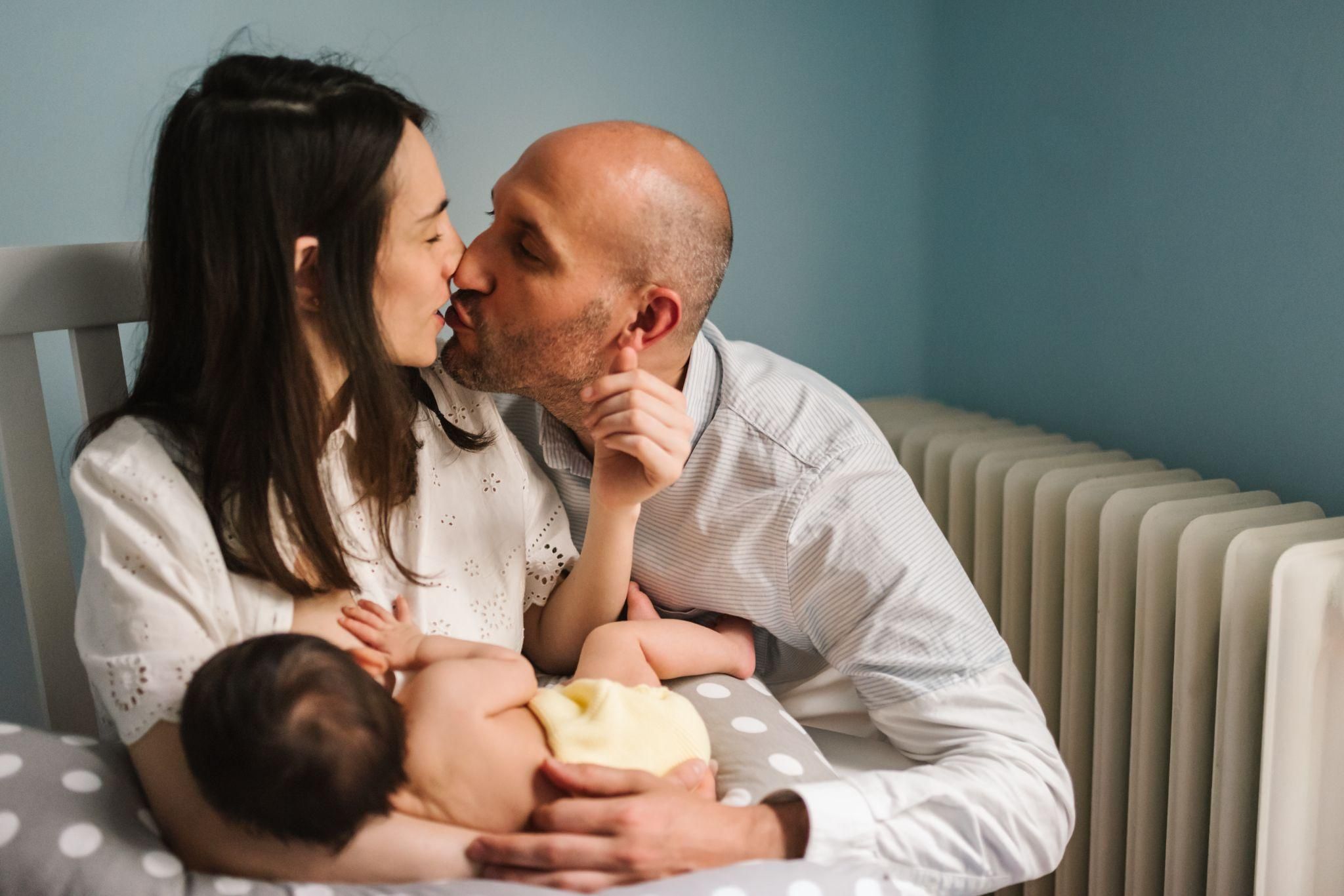 Happy new parents with baby at feeding time.