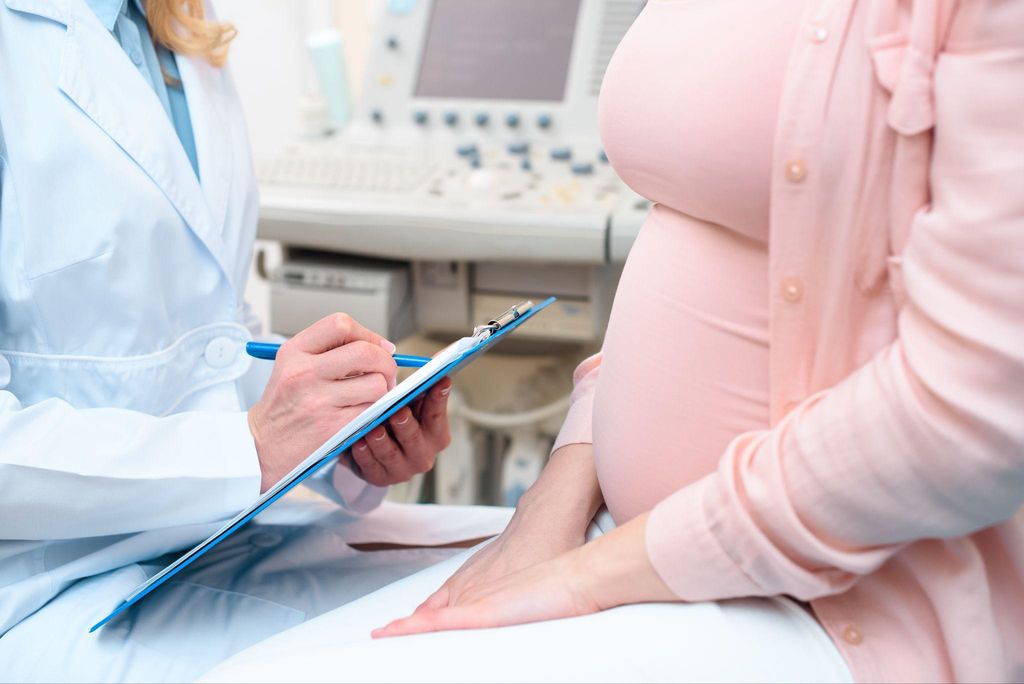 A pregnant woman and healthcare provider discussing antenatal screening results.