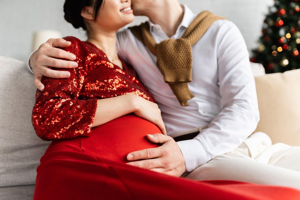 A pregnant couple embracing while discussing antenatal care and intimacy.