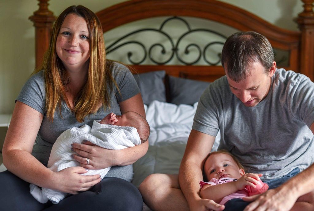 A couple preparing for a home birth with their midwife in a cosy, peaceful environment.