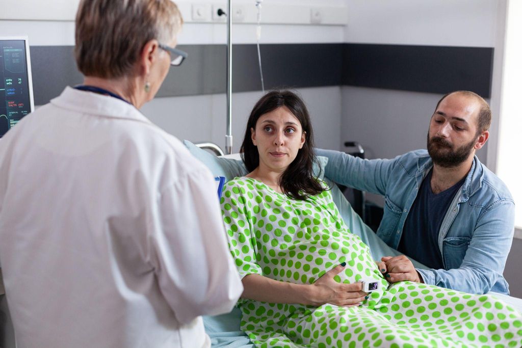 A healthcare provider discussing medical interventions with an expectant mother during an antenatal checkup.