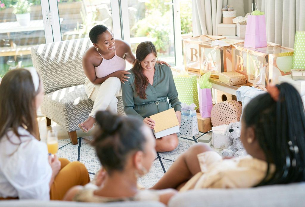 A group of friends enjoying interactive baby shower games with props and laughter.