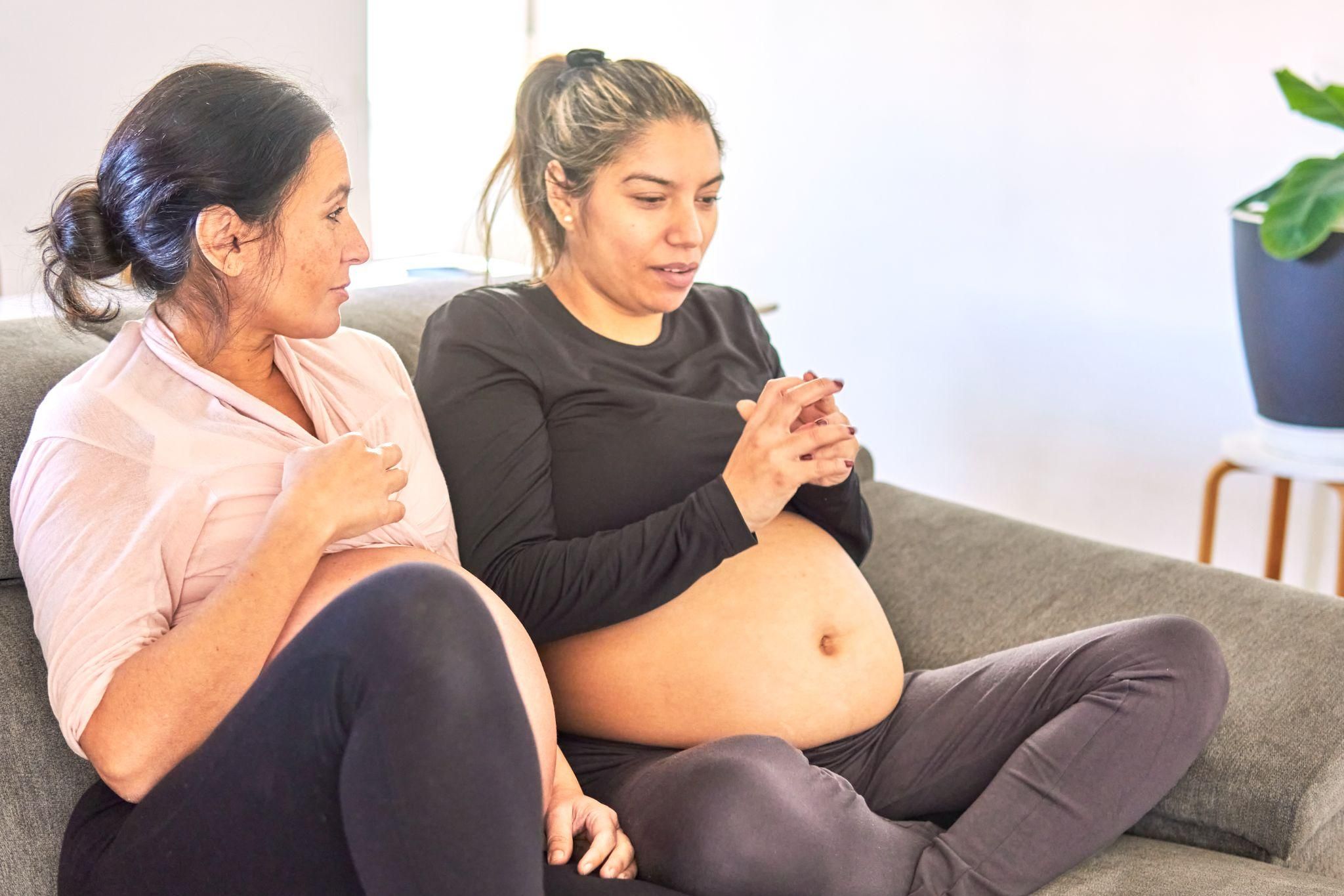 Pregnant friends bonding during yoga for pregnancy.