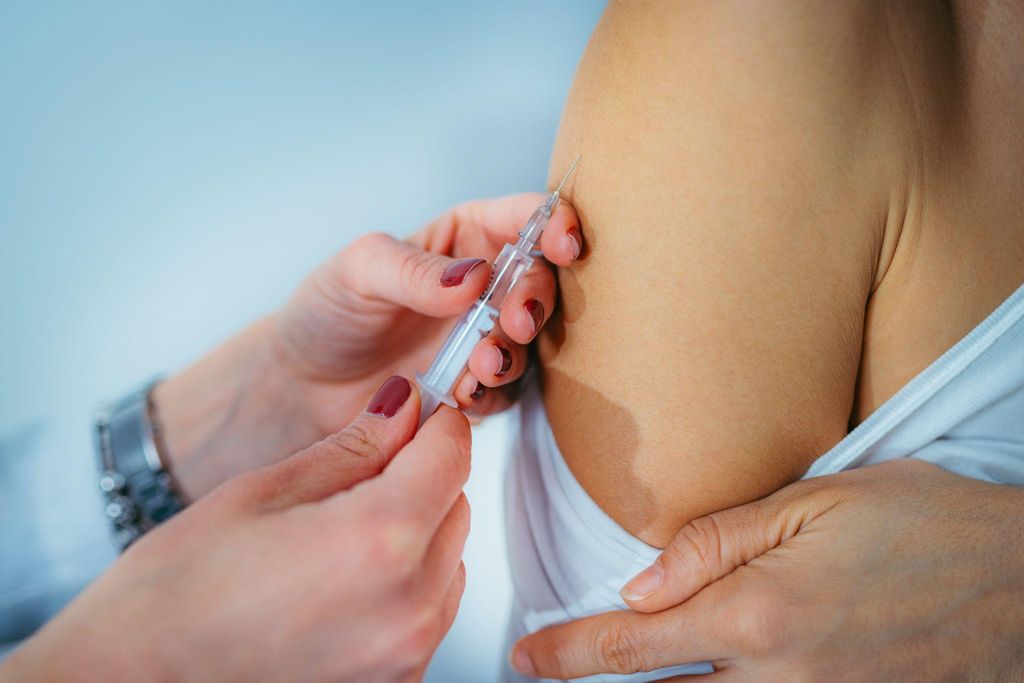 A healthcare professional administering a vaccine to a pregnant woman.