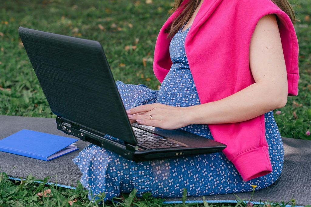 Pregnant woman reviewing documents related to maternity allowance with her partner.