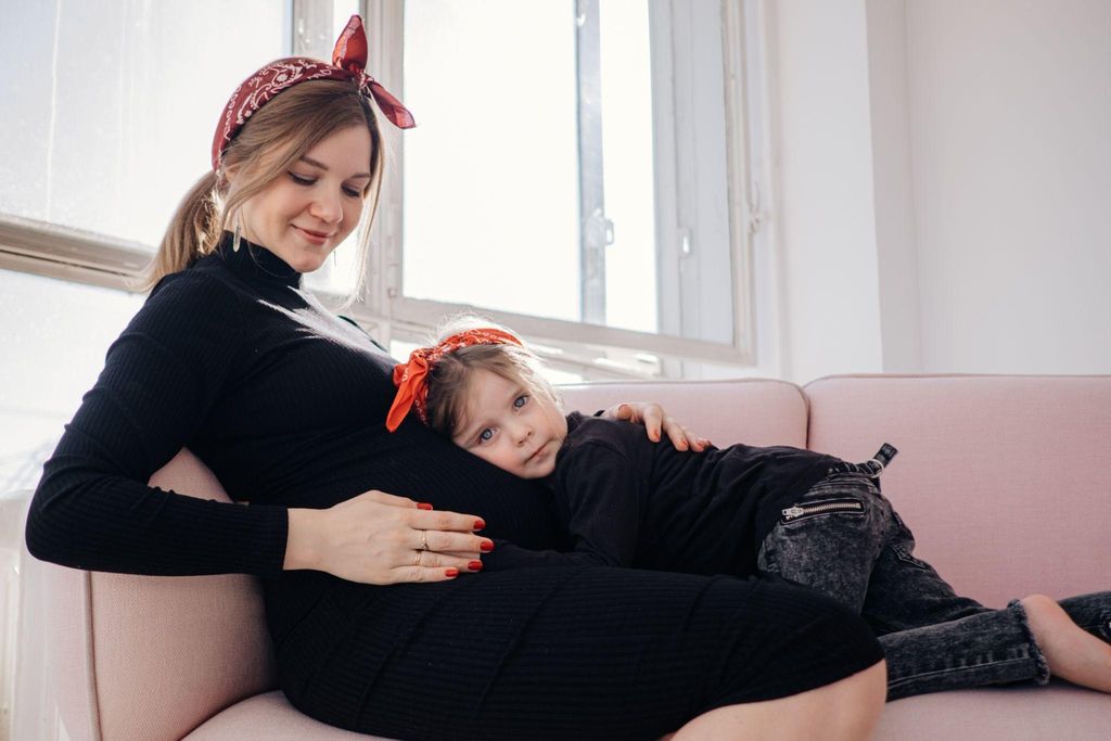 A little girl supporting a mother before a home birth in a calm, well-prepared environment.