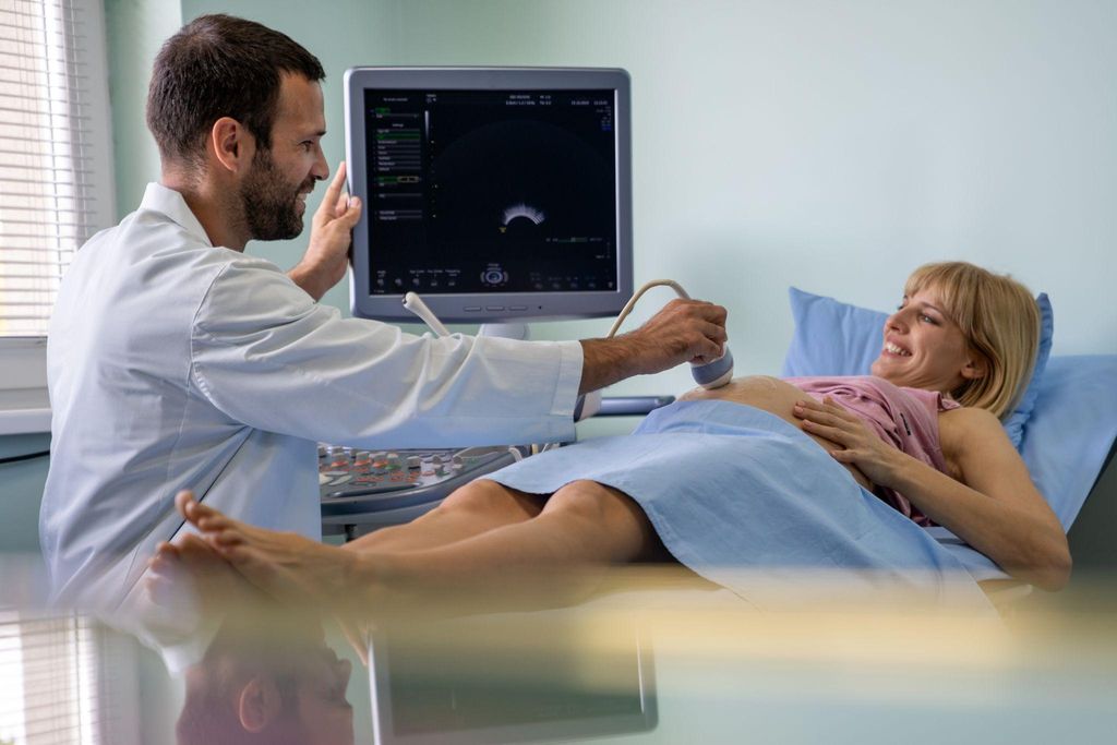 Pregnant woman having ultrasound scan during antenatal appointment.