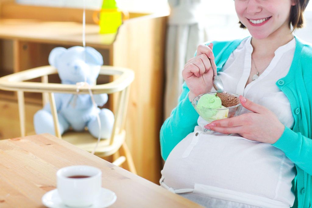 Pregnant woman making healthy food choices to manage cravings.