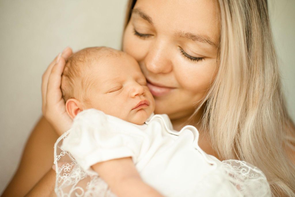 Happy parents holding their newborn baby, representing emotional connection after birth.