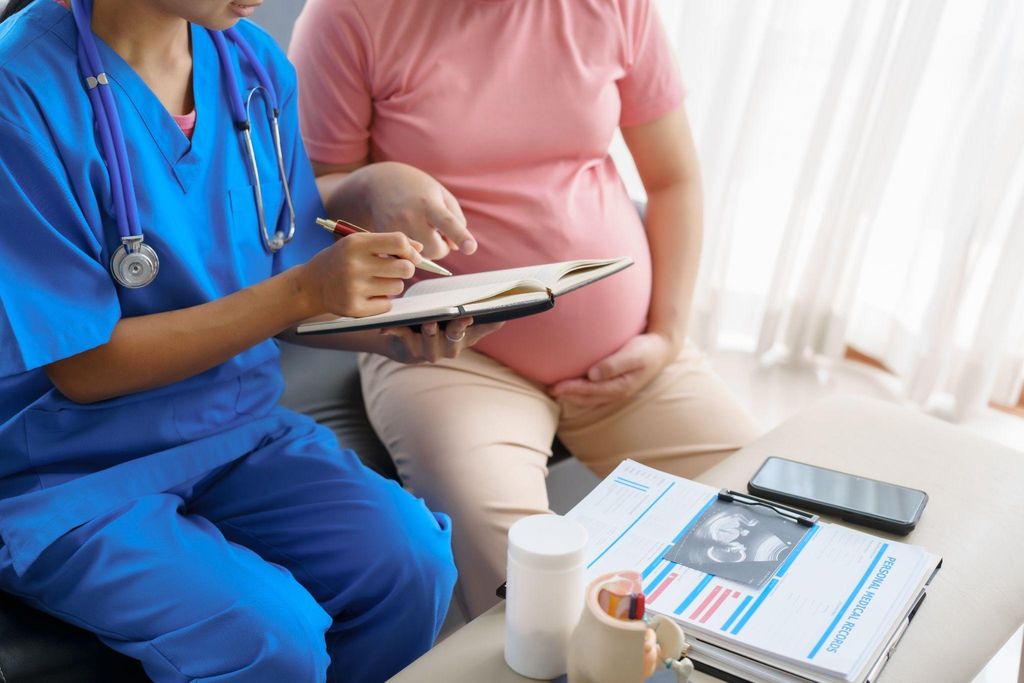 A doctor explaining antenatal tests to a pregnant woman at a clinic.