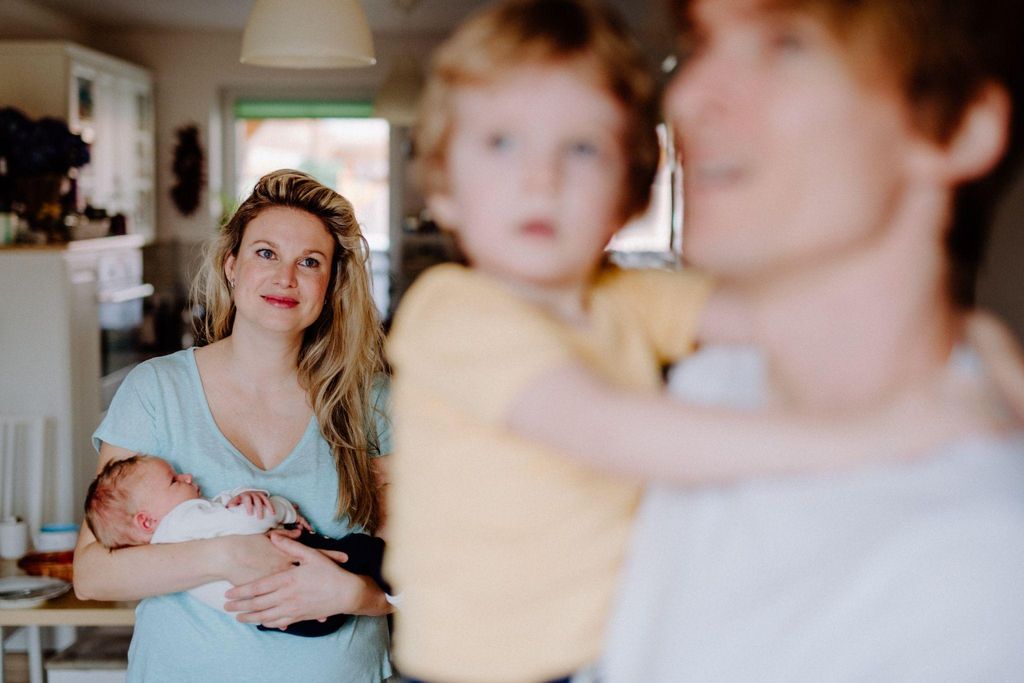 A postpartum woman relaxing in a family environment.