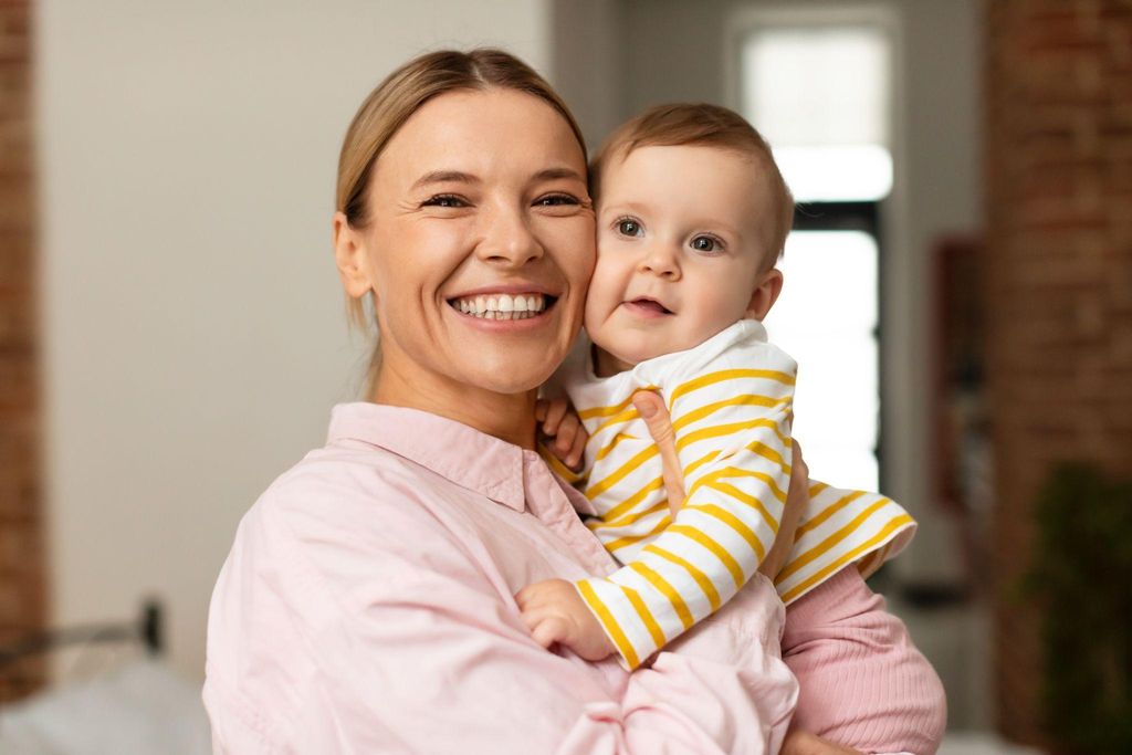 A new mother smiling with her baby.