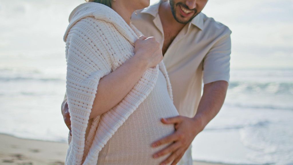 A supportive dad-to-be bonding with his pregnant wife during their antenatal journey.