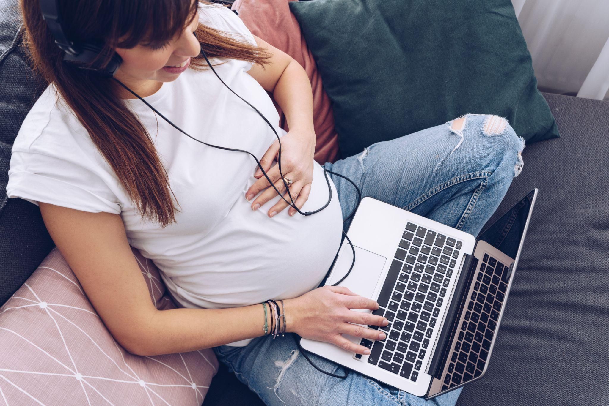 A pregnant woman browsing antenatal tools and resources on her laptop.