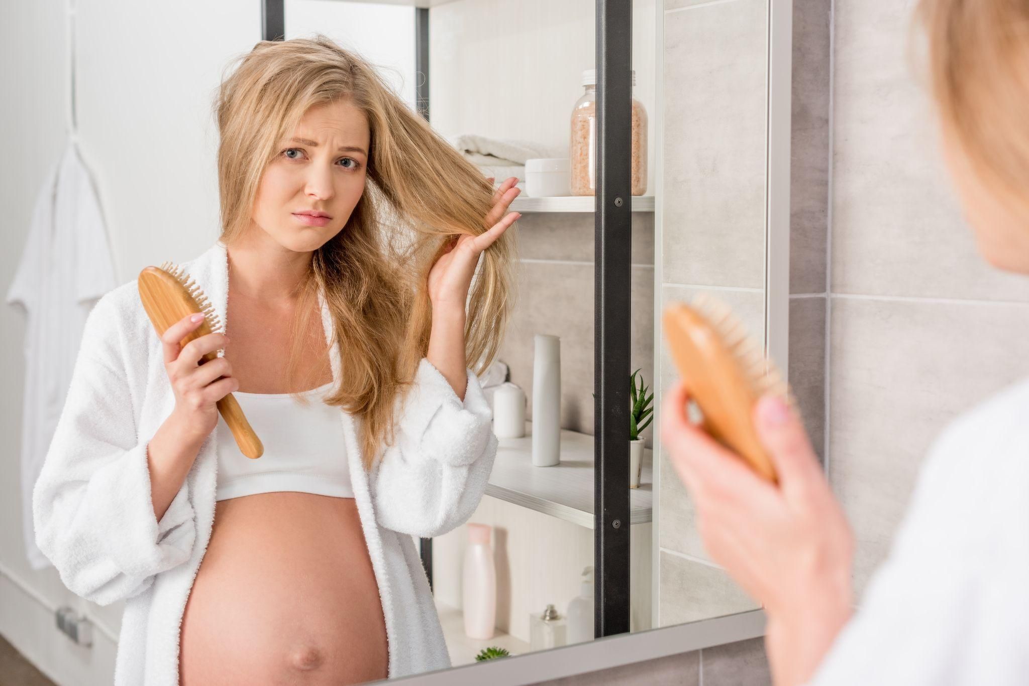 A close-up of a pregnant woman’s hair and a bottle of prenatal vitamins.