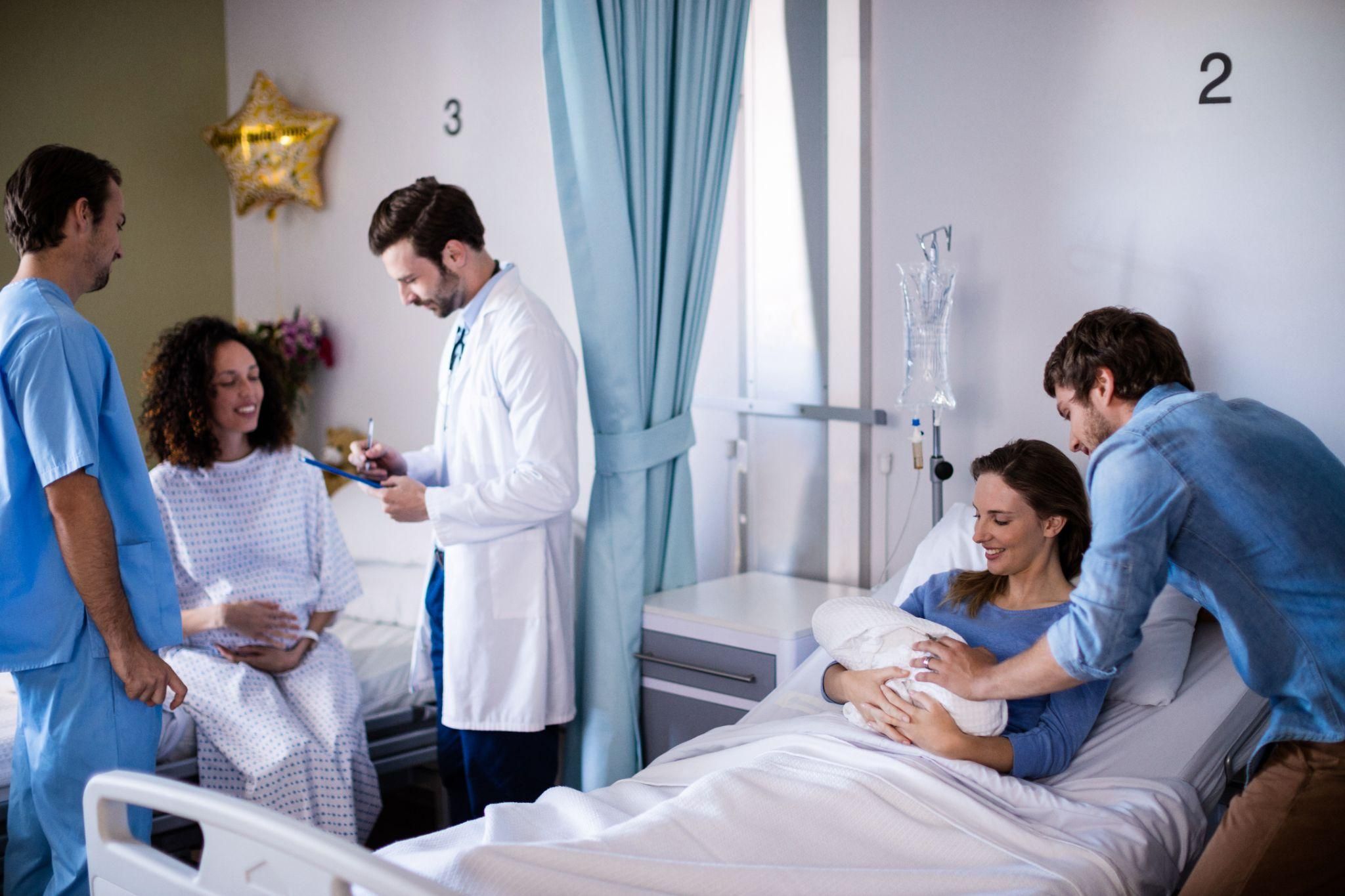 A mother bonding with her newborn baby right after birth in a hospital room.