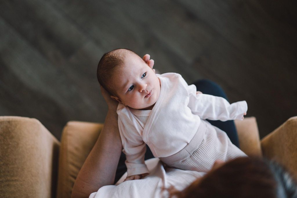 A father holding a newborn baby, reflecting on his