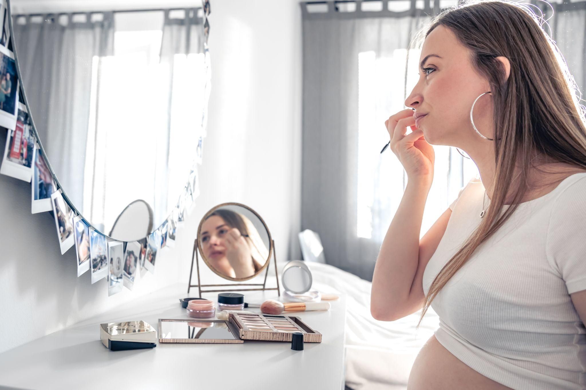 A mother looking at herself in the mirror after giving birth