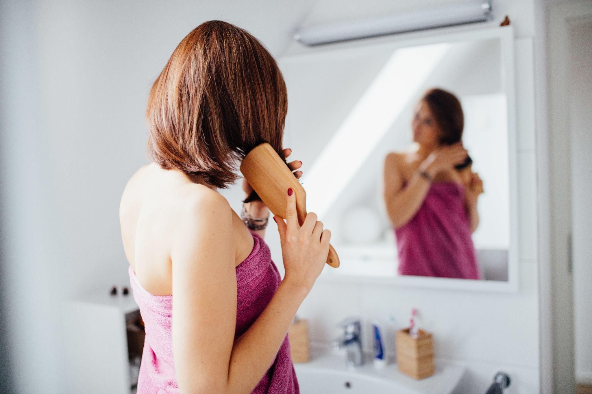 A relaxed mother practising hair care post-pregnancy.