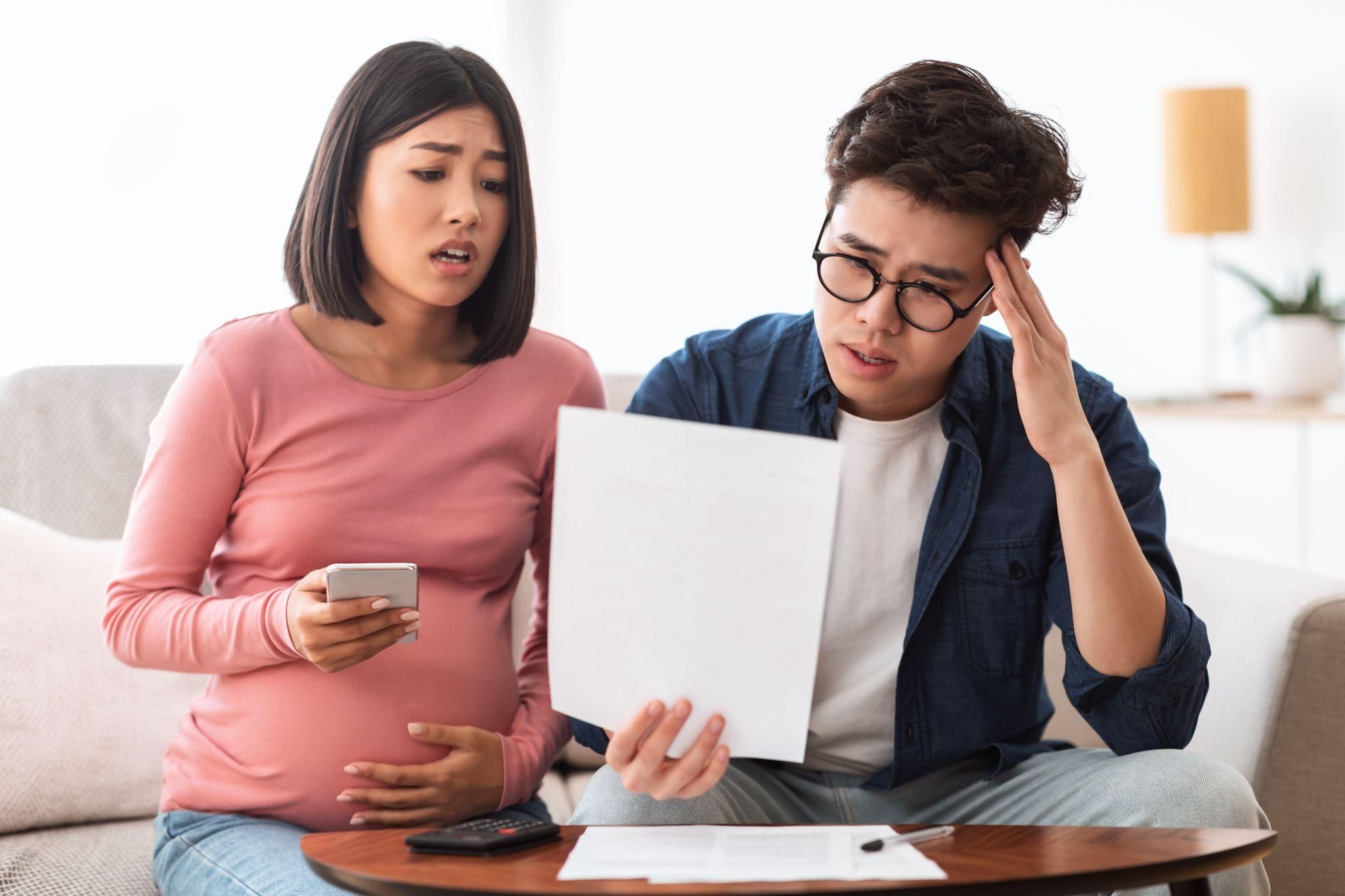 Parents-to-be creating a budget checklist for their baby’s arrival.