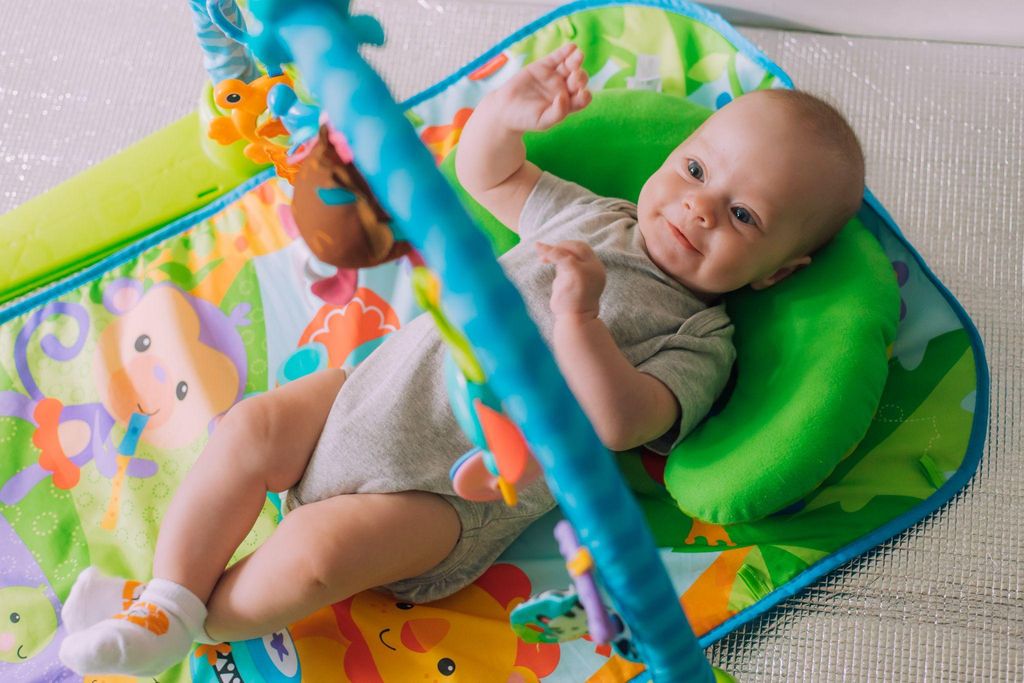 Baby play mats with interactive toys and textures displayed in a nursery.