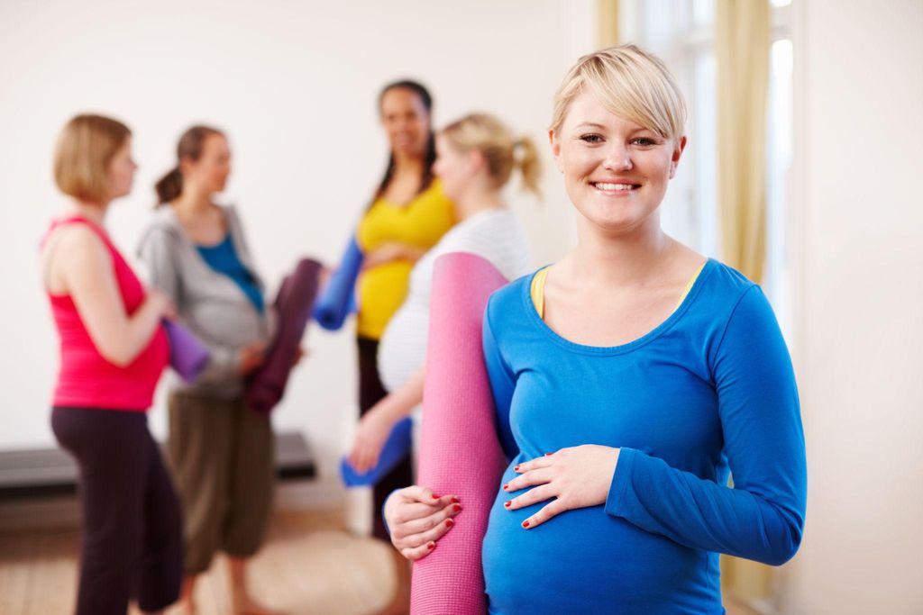 Pregnant women practicing yoga poses in a London yoga studio designed for pregnancy yoga classes.