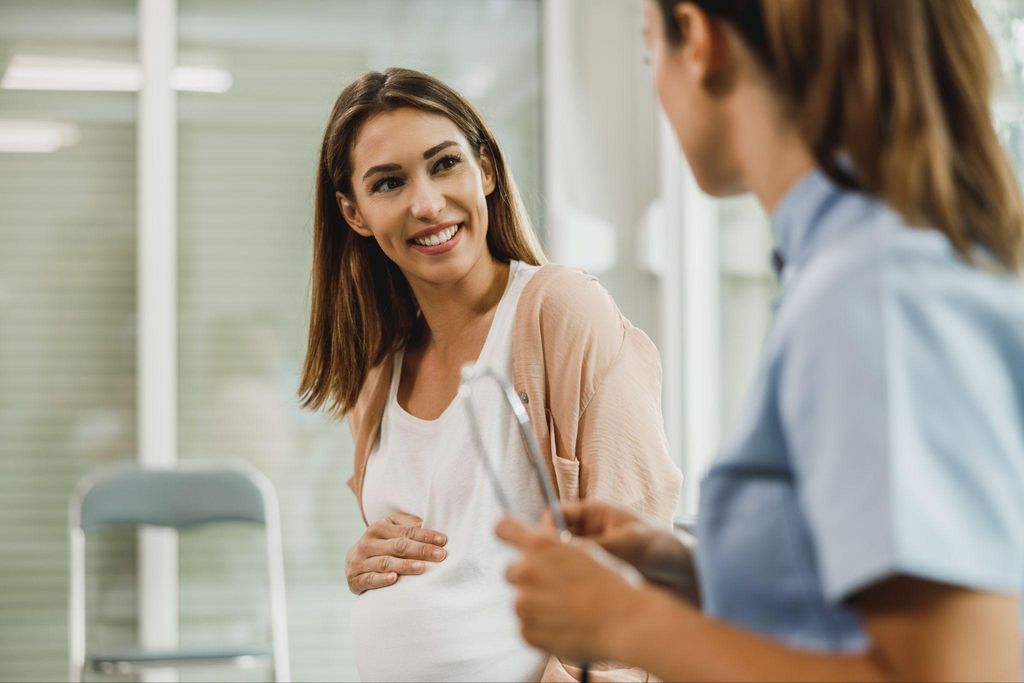 A pregnant woman discussing her mental health with a healthcare provider during an antenatal appointment.