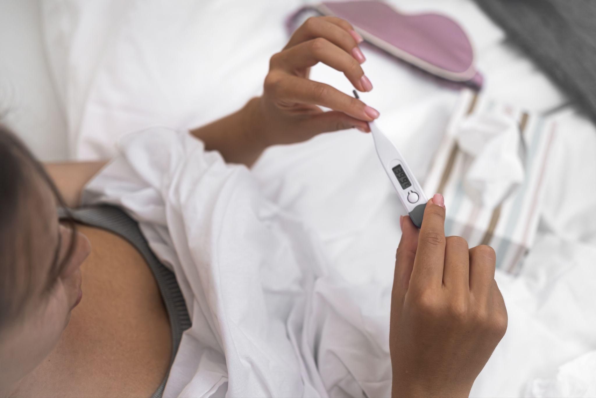 A close-up of positive and negative pregnancy test results displayed alongside antenatal vitamins and a notebook.