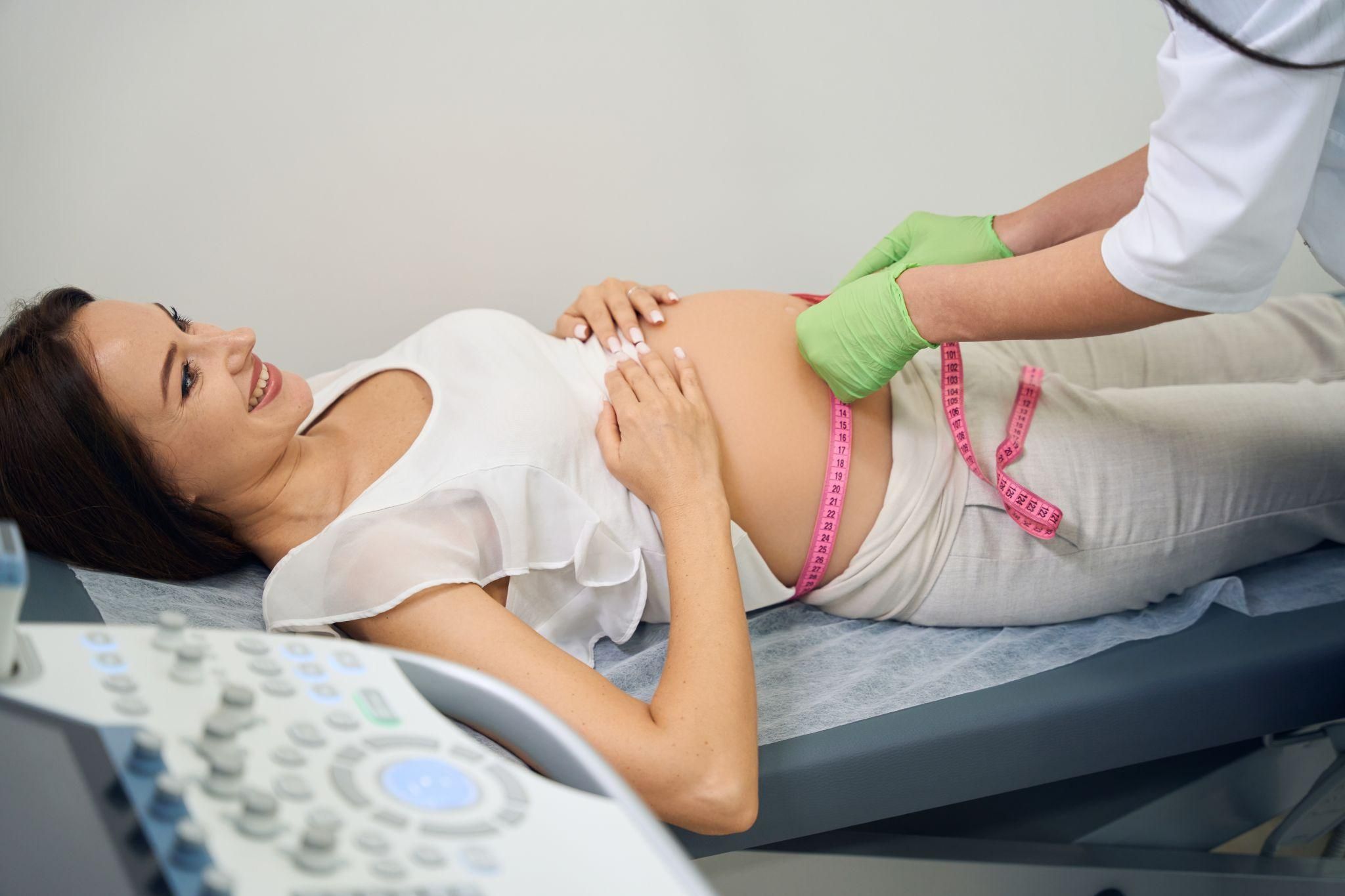 Pregnant woman has her bump measured as a partial check for FGR, which may cause pregnancy to be considered high risk, during a routine antenatal appointment.