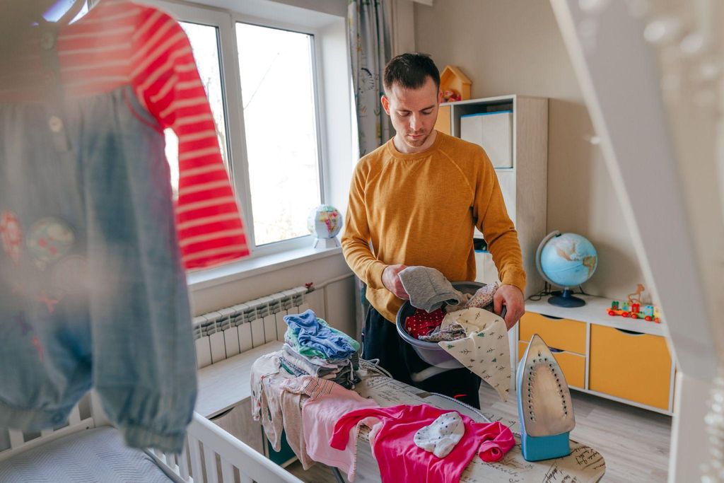 A father assisting his partner with baby care and household tasks after childbirth.