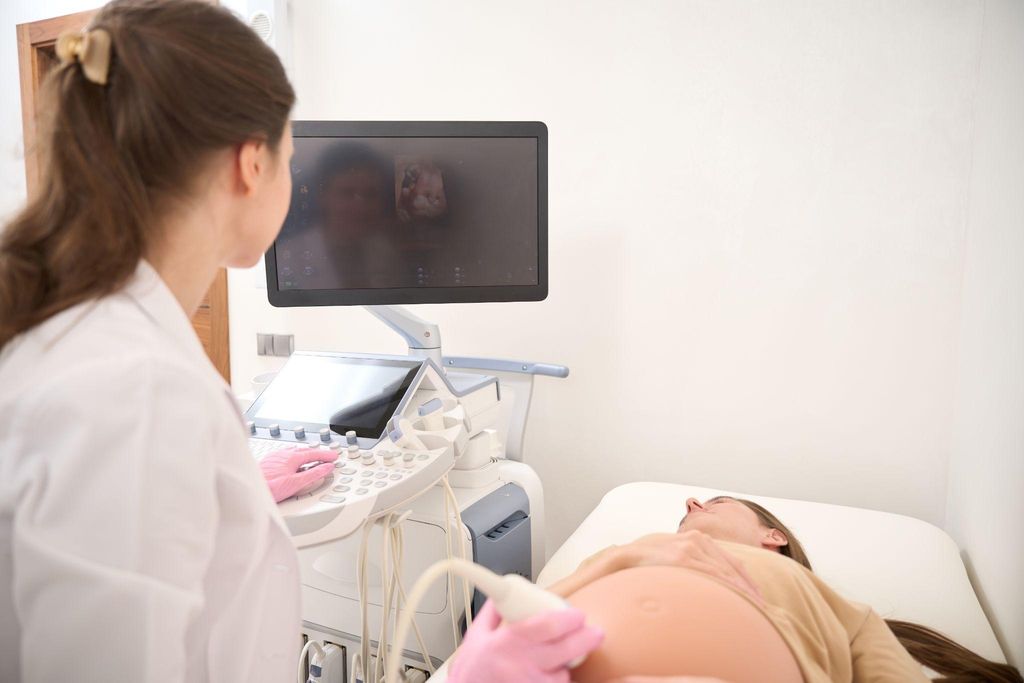 A healthcare provider performing an ultrasound during an antenatal appointment.