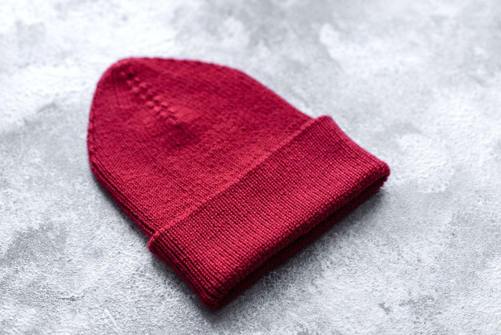 A knitted red hat for a newborn baby in the hospital.