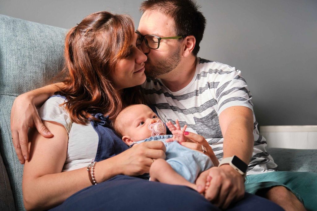 New parents embracing their newborn, adjusting to postpartum life