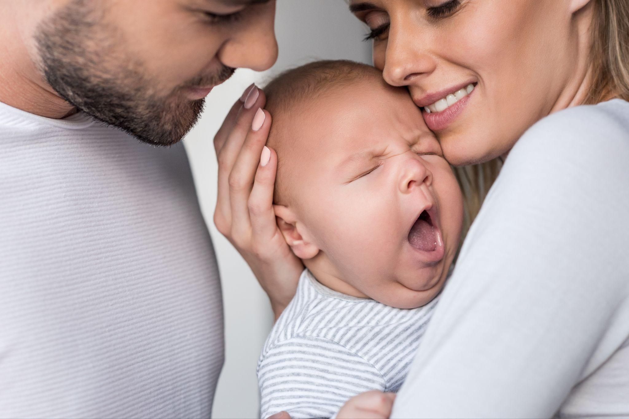 Hailey Bieber and Justin Bieber holding their newborn baby, Jack Blues Bieber, and smiling.