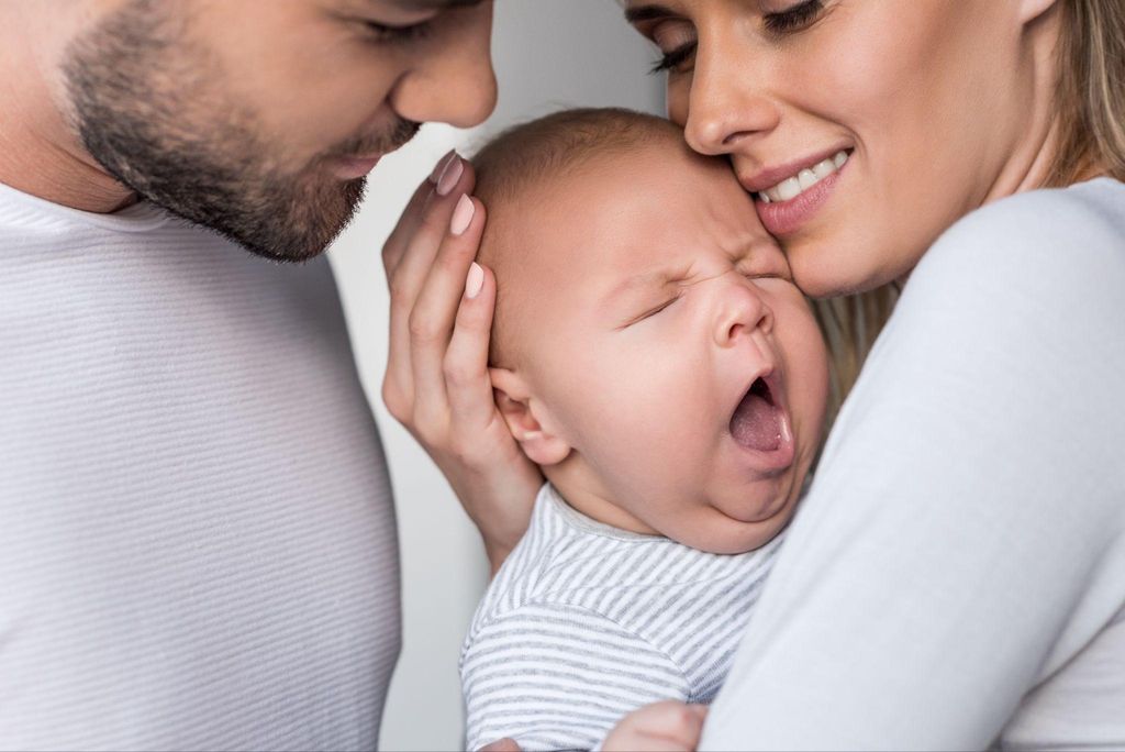 Hailey Bieber and Justin Bieber holding their newborn baby, Jack Blues Bieber, and smiling.