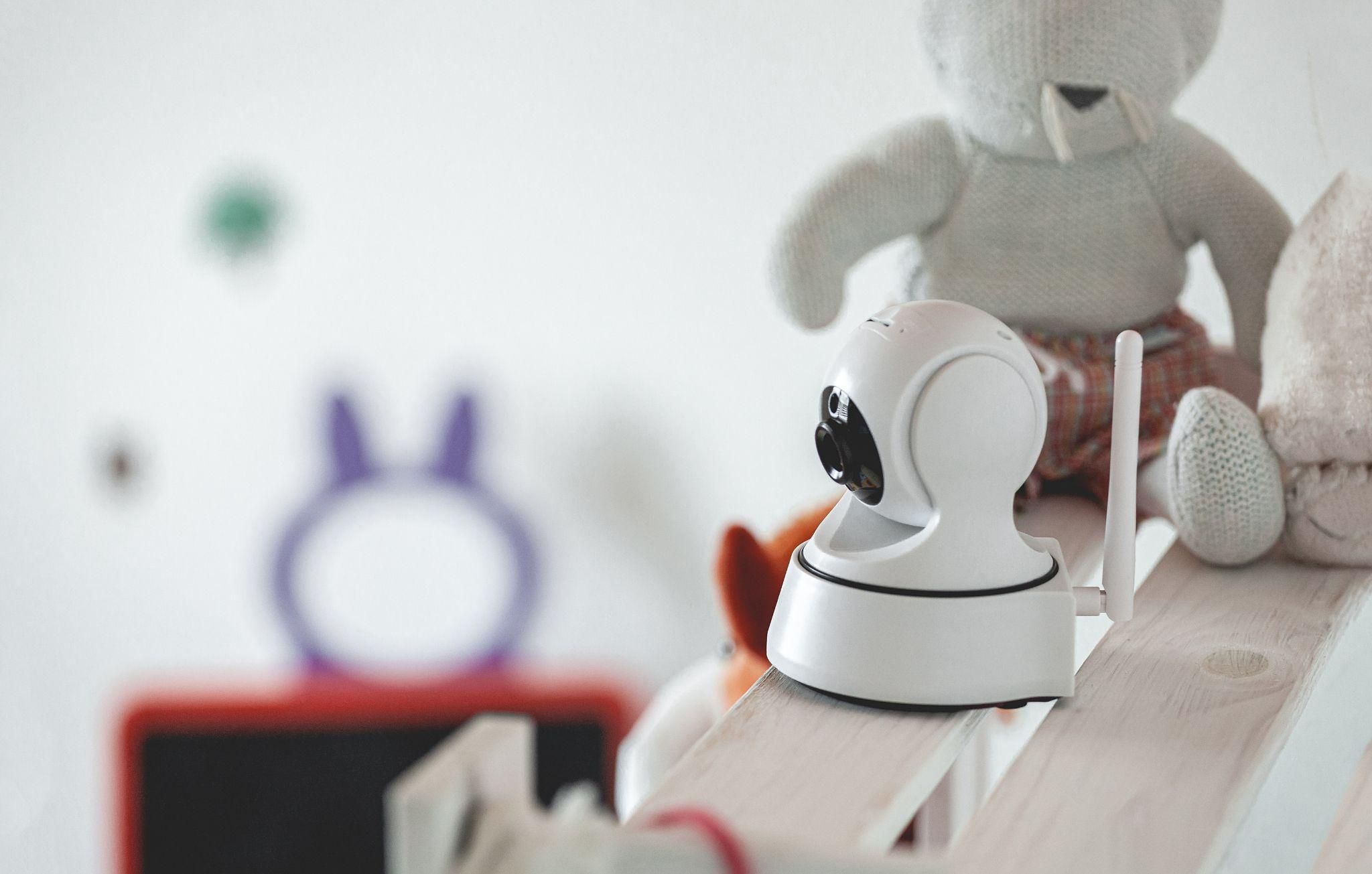 Various baby monitors featuring cameras, screens, and smart features, arranged neatly in a nursery setting.